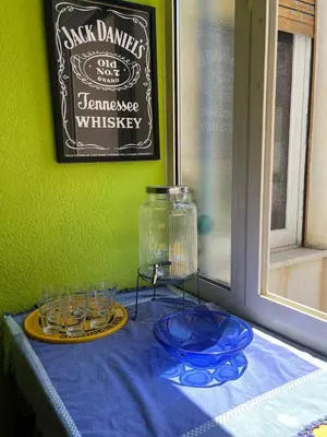 a table with a blue plate and glasses and a glass jar at Casina Della Strega in Palermo