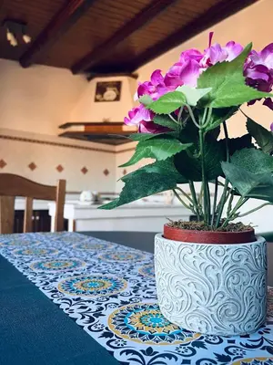 a white vase with purple flowers on a table at Sun House in Palermo