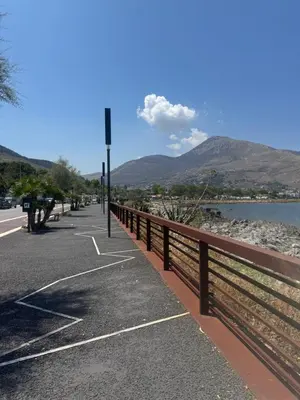 a road with a fence next to a body of water at Sun House in Palermo