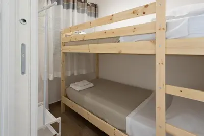 a bunk bed in a small room with a bunk bed in a room at Ludo Holiday House - Charming con patio a due passi dalla cattedrale in Palermo