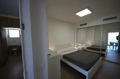 a bedroom with a bed and a mirror at IRIS HOME Private Pool in Alcamo