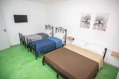 a room with two beds and a flat screen tv at Case D'irene in Capaci