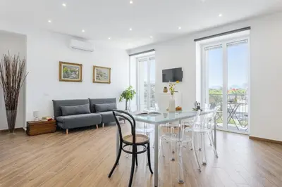 a living room with a table and chairs and a couch at Old Port Luxury Apartments in Palermo