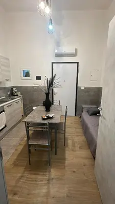 a kitchen with a table and a couch in a room at La casetta del centro in Palermo