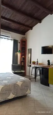 a bedroom with a bed and a table and a desk at Jujube hortus apartment 4 in Palermo