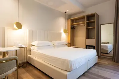a bedroom with a large white bed and a table at Mondello Glam Hotel & Terrace in Mondello
