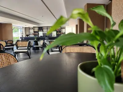 a dining room with a table and chairs and a plant at Mondello Glam Hotel & Terrace in Mondello