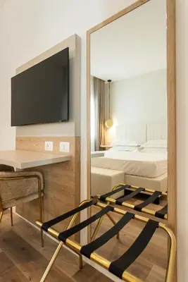 a room with two beds and a mirror at Mondello Glam Hotel & Terrace in Mondello