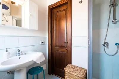 a bathroom with a sink and a wooden door at La Terrazza di Massimo in Palermo
