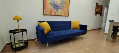 a blue couch with two yellow pillows in a living room at Casa Renda in Balestrate