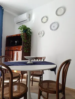 a table and chairs in a room with plates on the wall at Liberty Blue House in Palermo