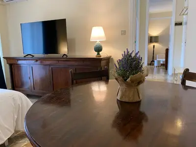 a living room with a wooden table and a television at Casa Verdura in Palermo