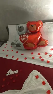 two teddy bears sitting on a bed with hearts at La casetta di Davide in Palermo