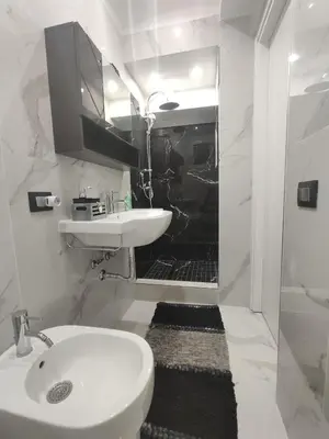 a white bathroom with a sink and a toilet at La casetta di Davide in Palermo