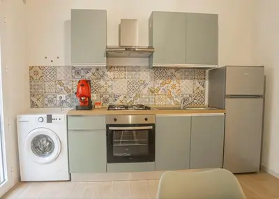 a kitchen with a washing machine and a washer at L'angolo di Leo in Isola delle Femmine