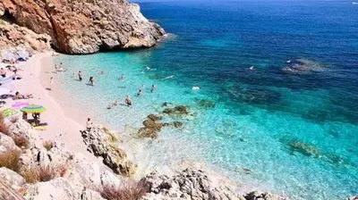 a group of people swimming in the water at a beach at Casa vacanze LoRiLù in Castellammare del Golfo