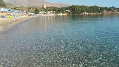 a beach with a body of water and some trees at Casa vacanze LoRiLù in Castellammare del Golfo