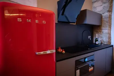 a red refrigerator in a kitchen with a sink at Boutique Apartment 