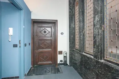 a wooden door in a hallway with blue walls at Sella Apartment Centro Storico in Palermo