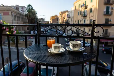a table with two cups and a drink on a balcony at Ai Mercati di Palermo in Palermo
