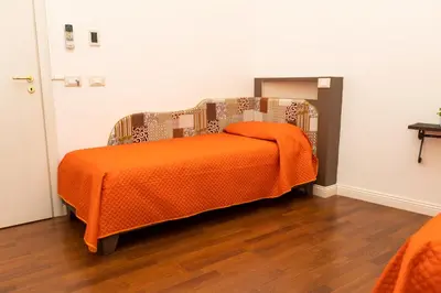 a bed with an orange blanket on it in a room at Ai Mercati di Palermo in Palermo