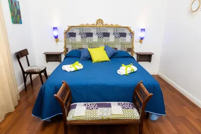 a bedroom with a blue bed with yellow pillows at Ai Mercati di Palermo in Palermo
