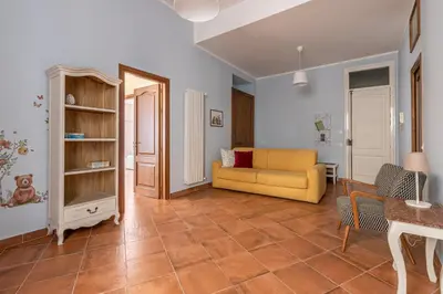 a living room with a yellow couch and a table at Il Cortile degli Aragonesi by Wonderful Italy in Palermo