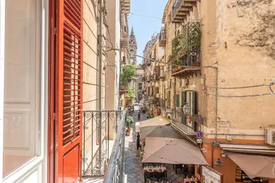 an alleyway between two buildings with an umbrella at Il Cortile degli Aragonesi by Wonderful Italy in Palermo