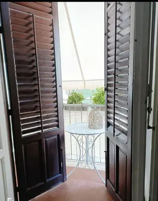 a door leading to a patio with a table on a balcony at Suite 374 in Palermo