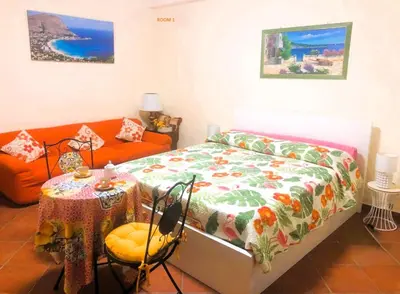a bedroom with a bed and a table and a couch at Mondello House Lemon in Palermo