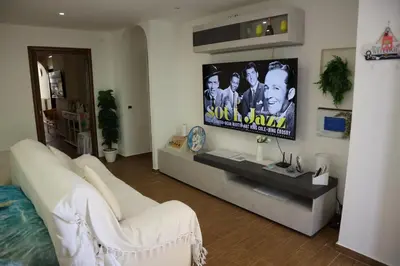 a living room with a couch and a flat screen tv at Mondello House Lemon in Palermo
