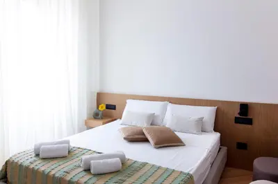 a bedroom with a large white bed with two pillows at Lùlom - Rooftop Boutique Rooms in Palermo