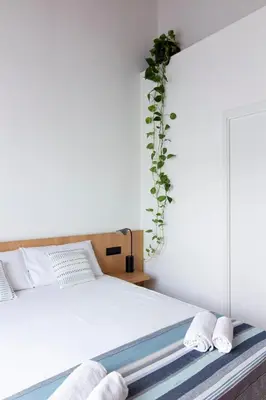 a bedroom with a bed with a plant on the wall at Lùlom - Rooftop Boutique Rooms in Palermo