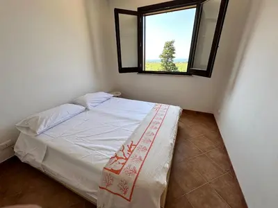 a small bedroom with a bed with a window at Casa Vacanza Villa Corona in San Vito lo Capo