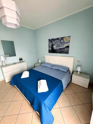 a bedroom with a blue bed with two towels on it at Appartamento Trinacria in Castellammare del Golfo