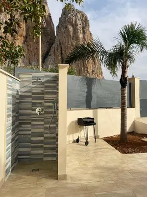 a bathroom with a shower and a palm tree at Monte Luna - E-bikes incluse per raggiungere il centro e la spiaggia in 3 minuti in San Vito lo Capo