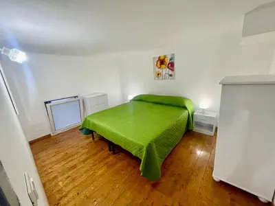 a bedroom with a green bed in a room at Alloggio delle Carrozze al Ballarò in Palermo
