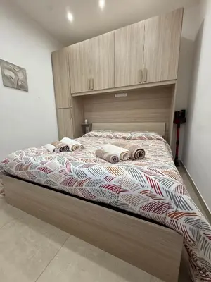 a bedroom with a bed and a dresser and two windows at Sopra Palermo in Monreale