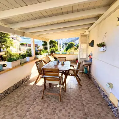 a porch with a table and chairs on a patio at La Terrazza su Mondello in Palermo