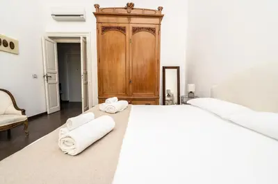 a bedroom with a large bed with towels on it at Maison d'art Orleans in Palermo