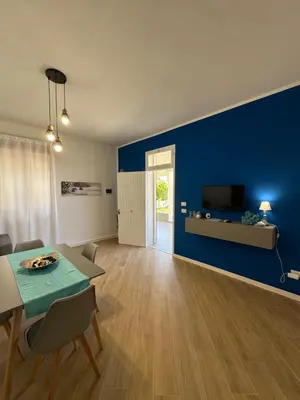 a living room with a table and a blue wall at casa consiglio ardicula in Terrasini
