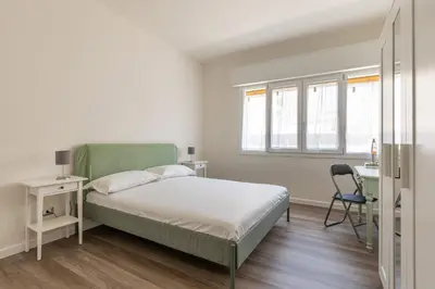 a bedroom with a bed and a chair and a desk at Appartamento Pacini by Wonderful Italy in Palermo