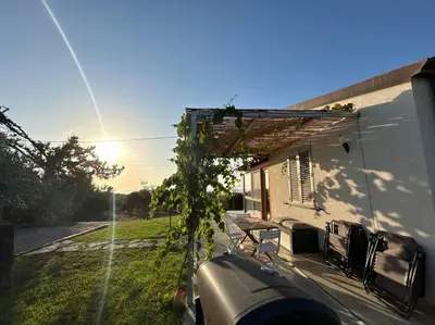 a view of a house with a table and a bench at Sunset Holiday House in Cefalù