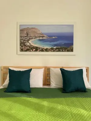 a bedroom with a bed with green and white pillows at My Happy Place Rooms in Palermo