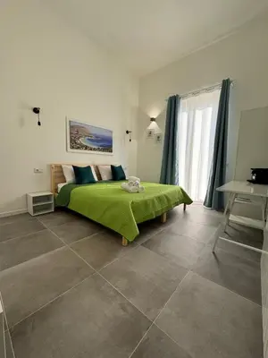 a bedroom with a bed with a green blanket on it at My Happy Place Rooms in Palermo