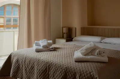 a bedroom with two towels on a bed with a window at Casa Margherita in Termini Imerese