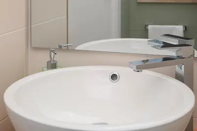 a bathroom with a white sink and a mirror at Anna's Central Apartment in Palermo