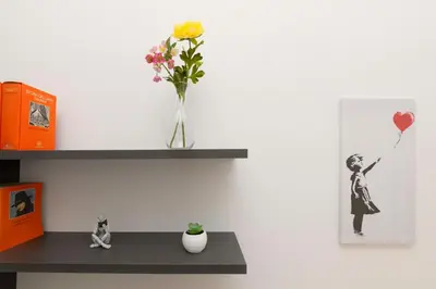 a vase with a yellow flower sitting on a shelf at Anna's Central Apartment in Palermo