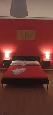 a bedroom with a bed with red walls and two lights at new suite in Palermo