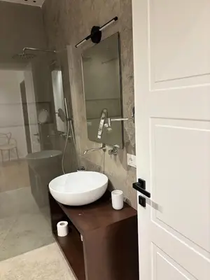 a bathroom with a white sink on a wooden counter at B&B Sulle Vie del Capo in Palermo